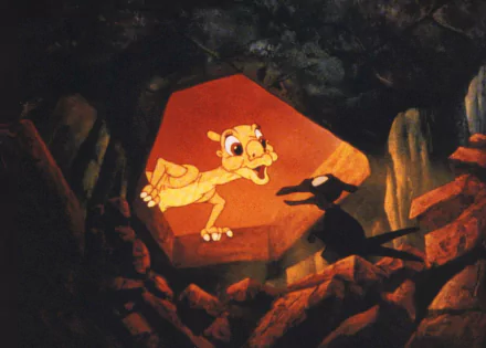 HD PC desktop wallpaper: scene from the movie The Land Before Time showing a young dinosaur peering out of a rocky cave into warm orange light.