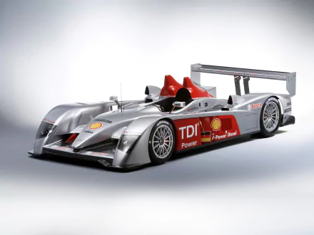 HD desktop wallpaper featuring a sleek Audi R10 TDI race car with silver body and red accents, showcasing its aerodynamic design and powerful performance.