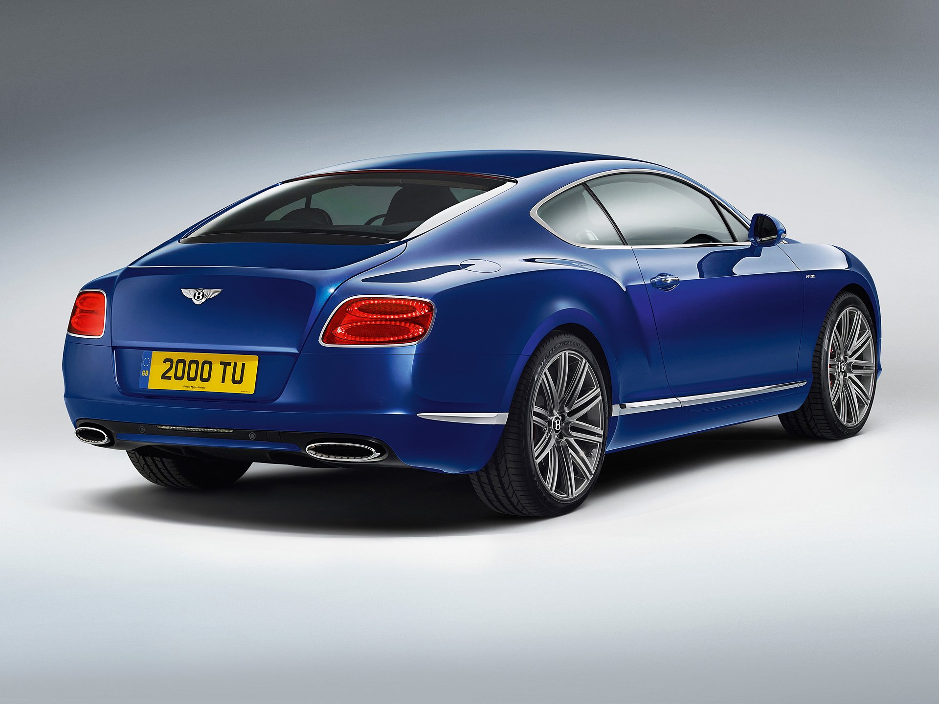 HD desktop wallpaper featuring a sleek blue Bentley Continental GT Speed fastback coupé grand tourer.