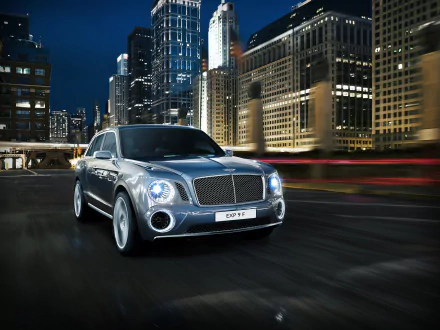 Silver Bentley EXP 9 F Concept SUV racing through a lit city at night — HD PC desktop wallpaper background showcasing the luxury vehicle in motion.