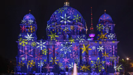 Artistic HD PC desktop wallpaper and background of Berlin's Festival of Lights: cathedral façade lit with vibrant star and snowflake projections against a dark night sky.