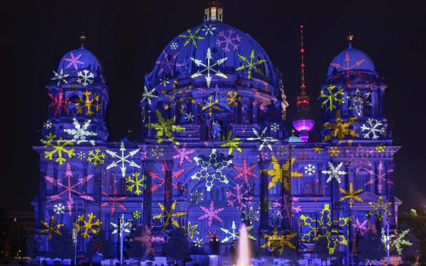 Artistic HD PC desktop wallpaper and background of Berlin's Festival of Lights: cathedral façade lit with vibrant star and snowflake projections against a dark night sky.