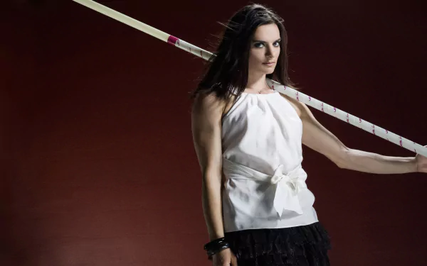 HD desktop wallpaper of Yelena Isinbayeva posing with a pole vault pole against a dark red background, highlighting her sports career.