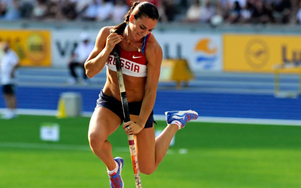 HD desktop wallpaper featuring Yelena Isinbayeva in action during a pole vault event, capturing the intensity and athleticism of sports.