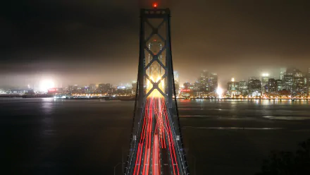 Night view of the Willie Brown Bridge, part of the San Francisco Bay Bridge, with city lights and light trails captured in 4K Ultra HD quality.