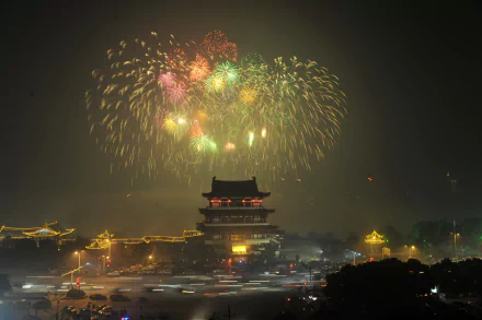 Man-made Changsha nightscape with fireworks above an illuminated traditional tower, 2K Quad HD PC desktop wallpaper/background.