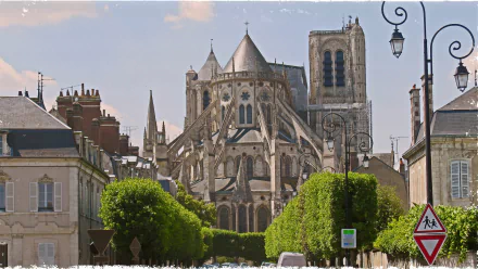 HD PC desktop wallpaper background showing Bourges Cathedral — religious Gothic façade, flying buttresses and towers framed by a tree-lined street.