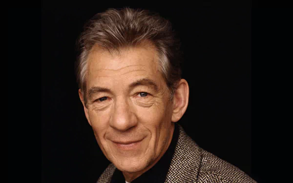 A high-definition desktop wallpaper featuring the esteemed celebrity Ian McKellen, showcasing a warm smile against a dark background.