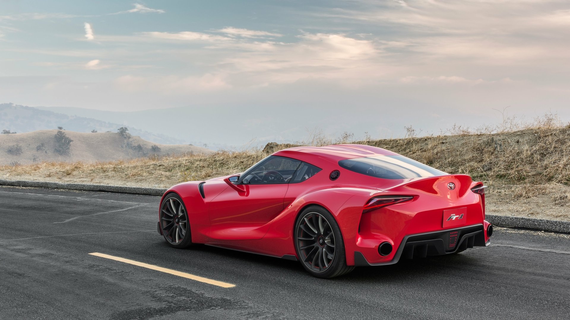 A striking Toyota FT-1 supercar showcases its sleek design against a scenic backdrop, making it an eye-catching HD wallpaper for car enthusiasts.