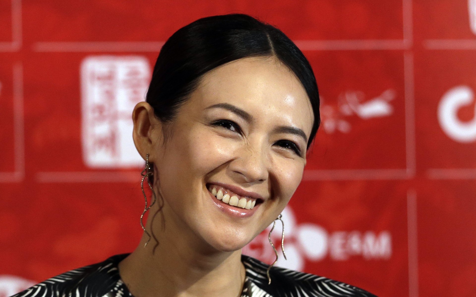 HD desktop wallpaper featuring Chinese actress and celebrity Zhang Ziyi smiling against a red background.