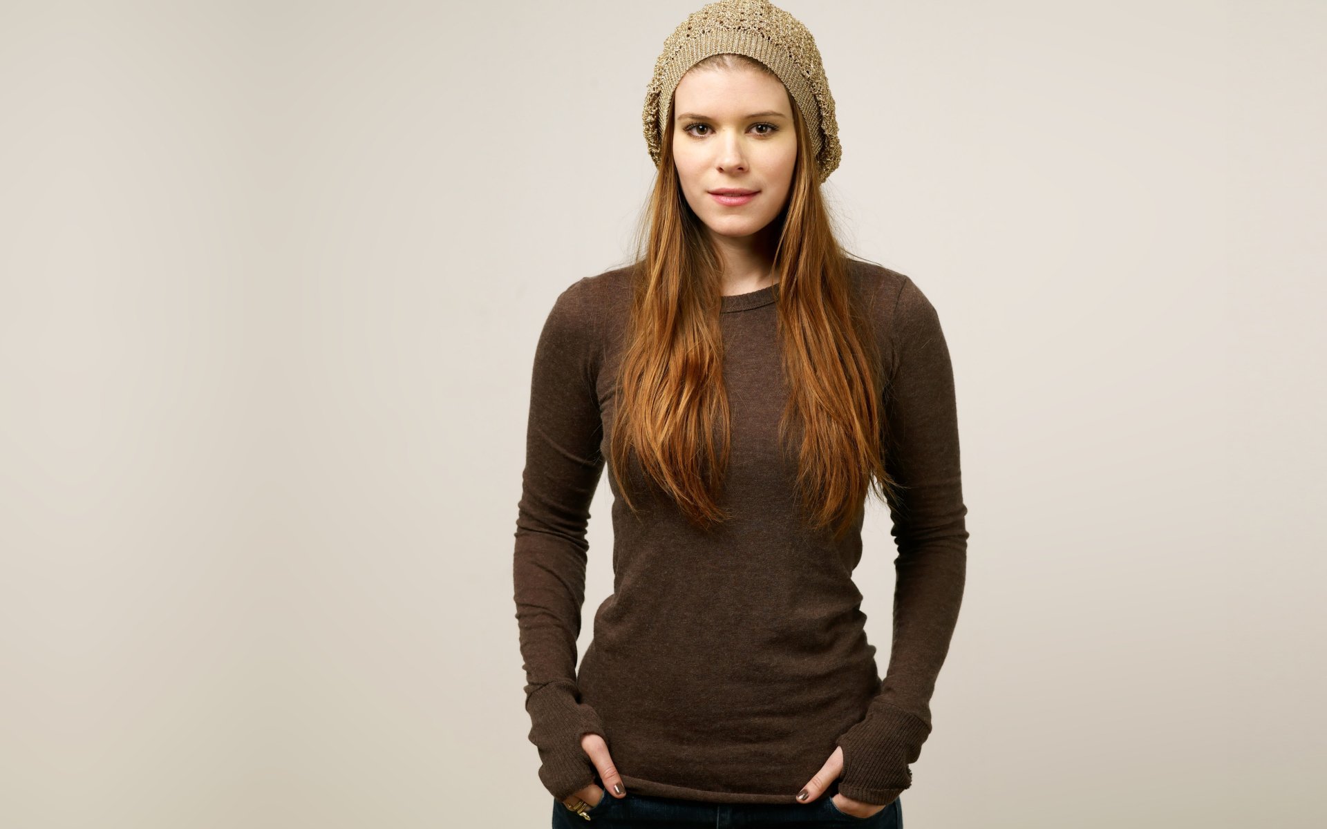 Portrait of American actress Kate Mara in a casual brown long-sleeve top and knit hat, captured in high-resolution 4K Ultra HD for a PC desktop wallpaper.