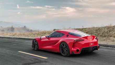 A striking Toyota FT-1 supercar showcases its sleek design against a scenic backdrop, making it an eye-catching HD wallpaper for car enthusiasts.