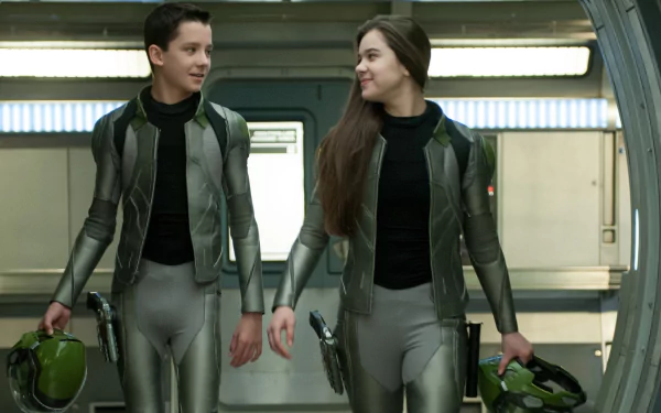 Two young crew members in gray flight suits carry helmets and walk down a corridor, Ender's Game movie 2K Quad HD PC desktop wallpaper/background.