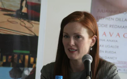 HD PC desktop wallpaper featuring British actress and celebrity Julianne Moore speaking into a microphone at an event.