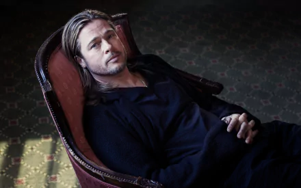 High-resolution 4K Ultra HD wallpaper of American actor Brad Pitt reclining in a chair, inspired by his role in the movie Killing Them Softly.