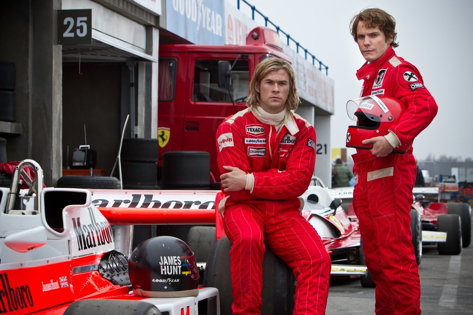 HD wallpaper from Rush (2013) featuring actors in racing suits beside a Formula One car with James Hunt text.