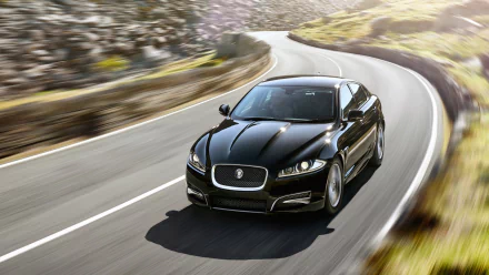 Black Jaguar XFR cruising a curving mountain road, rendered as an HD PC desktop wallpaper and background.