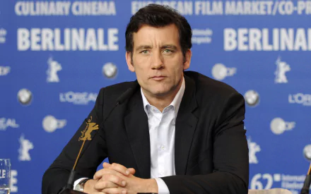 HD desktop wallpaper featuring English actor Clive Owen at a Berlinale film event, with a blue backdrop displaying festival logos and text.
