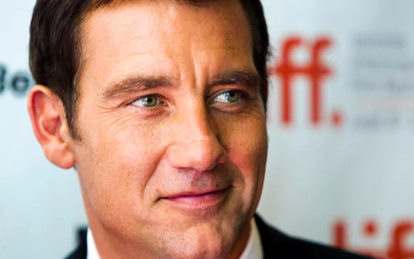 HD desktop wallpaper of English actor and celebrity Clive Owen, featuring a close-up portrait with a softly blurred event background.