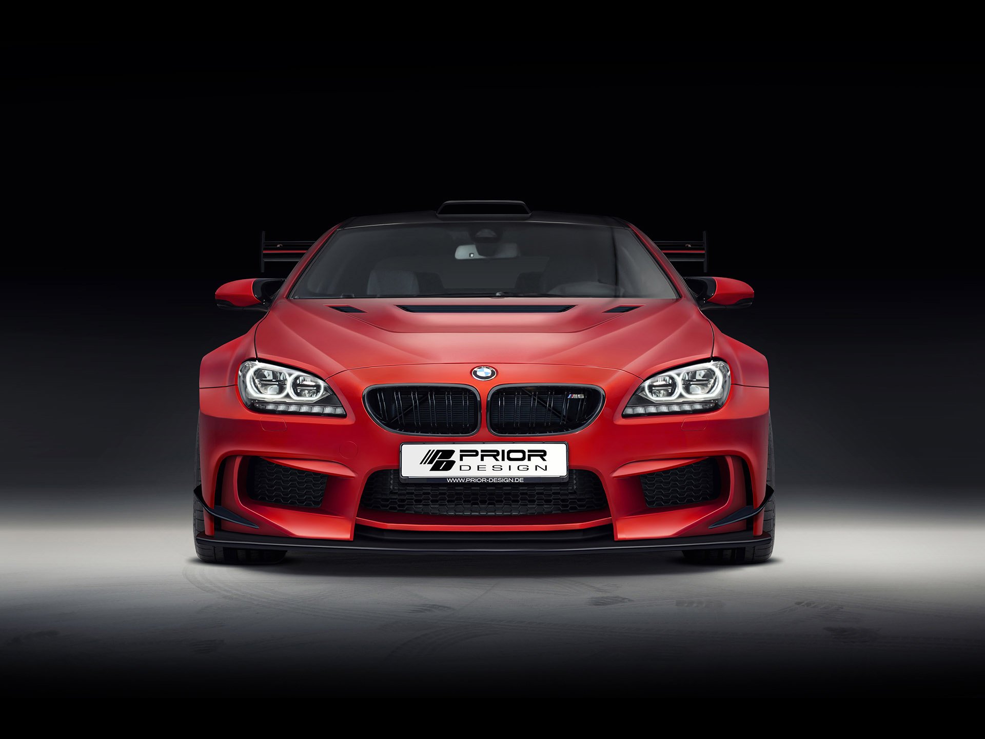 Front view of a red Prior Design BMW M6 showcased in an HD PC desktop wallpaper with a dark background highlighting the vehicle’s aggressive design.