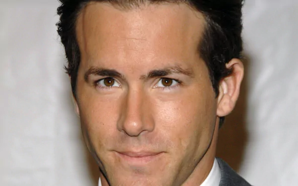 HD desktop wallpaper featuring a close-up of Ryan Reynolds in a suit with a neutral expression.