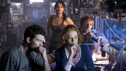 HD PC desktop wallpaper featuring a tense scene from the movie Avatar with four characters immersed in a dimly lit, high-tech laboratory setting.