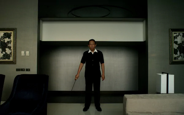 Vithaya Pansringarm from the movie Only God Forgives stands centered in a dimly lit modern room, holding a weapon in this 4K Ultra HD PC desktop wallpaper.