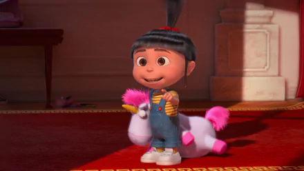 HD wallpaper featuring Agnes from Despicable Me 2, happily holding a toy unicorn in a warmly lit room.