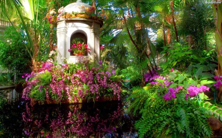 A vibrant garden scene featuring a decorative fountain surrounded by lush greenery and clusters of colorful flowers, showcased as a high-definition desktop wallpaper.