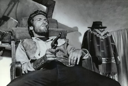 Black and white 4K Ultra HD PC wallpaper featuring Clint Eastwood in a scene from the movie For A Few Dollars More, holding a gun with a rugged Western backdrop.
