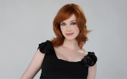 Christina Hendricks, an American actress and celebrity, poses elegantly in a stylish black dress, showcasing her signature red hair in this HD desktop wallpaper.