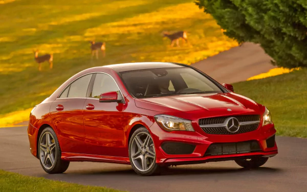 Red Mercedes-Benz CLA-Class vehicle on a winding country road at golden hour — HD PC desktop wallpaper background.