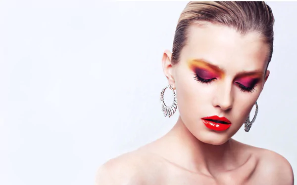 HD desktop wallpaper featuring French model Sigrid Agren with striking red and yellow eye makeup and bold red lipstick against a clean white background.
