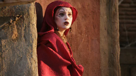 HD PC desktop wallpaper featuring Amy Pond from the TV show Doctor Who (2005) dressed in a red cloak against a textured stone background.