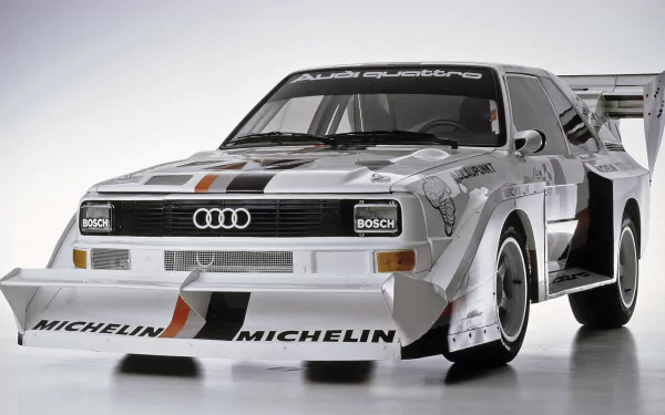 HD desktop wallpaper featuring a detailed Audi Quattro rally car with Michelin branding, showcasing its iconic design and motorsport heritage.