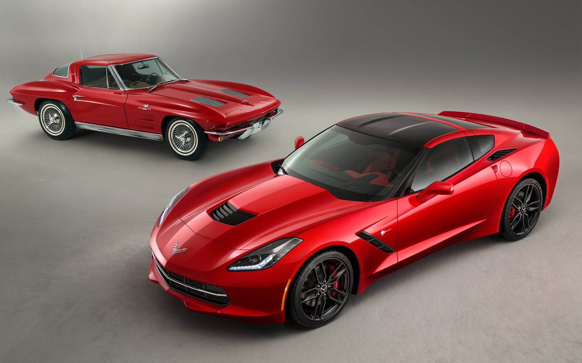 HD PC desktop wallpaper featuring a red Chevrolet Corvette Stingray Coupe alongside a classic red Chevrolet vehicle, showcasing the evolution of the Corvette design.