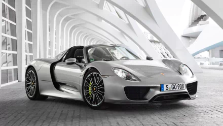 HD desktop wallpaper featuring a silver Porsche 918 Spyder parked under a modern architectural structure, showcasing its sleek design and sporty elegance.