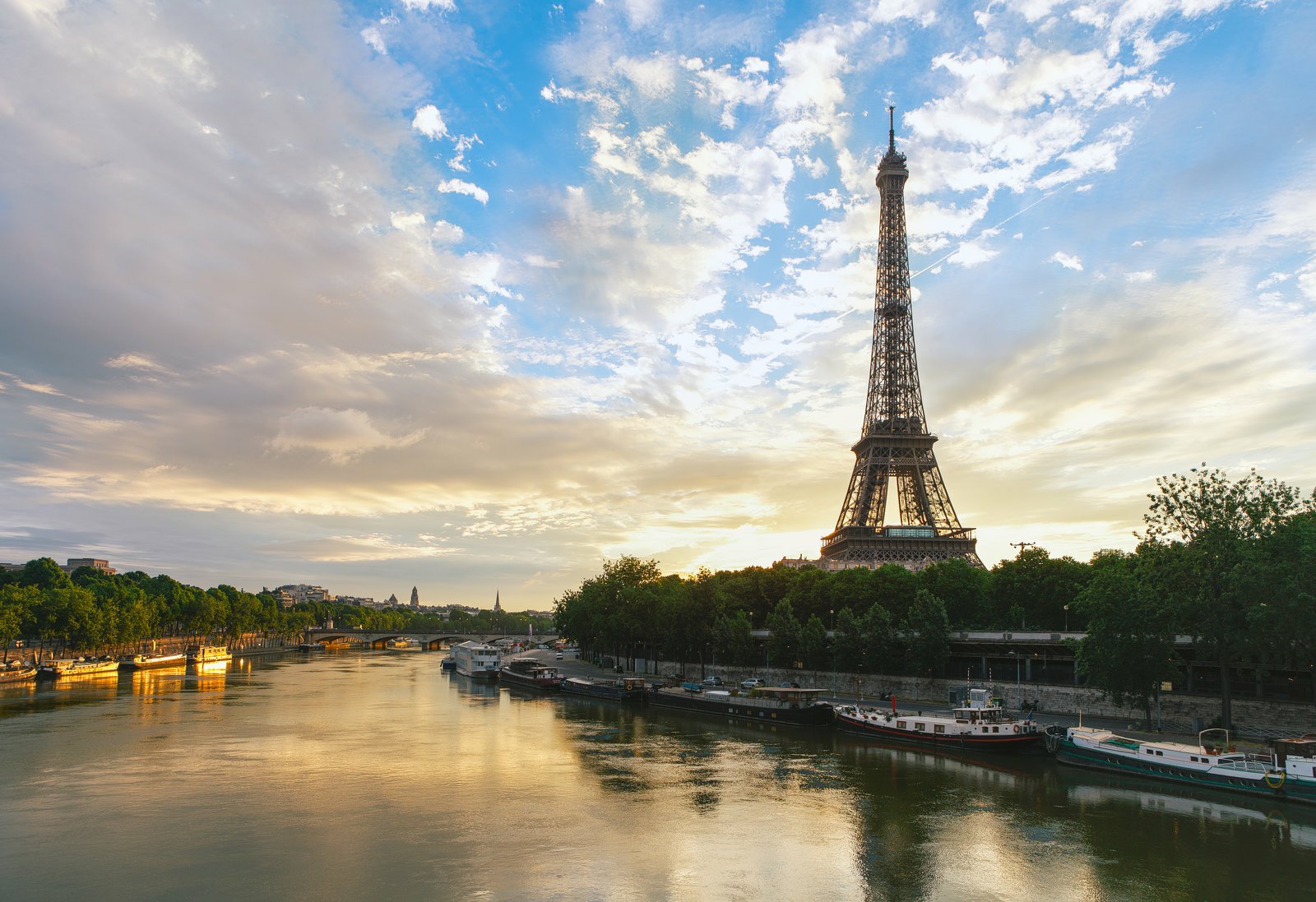 A stunning view of the Eiffel Tower in Paris, reflecting on the serene Seine River under a colorful sky, capturing the essence of the city's iconic skyline. 
