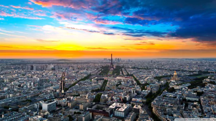 HD desktop wallpaper: Paris cityscape at sunset, Eiffel Tower centered with La Défense skyscrapers on the skyline — a dramatic man-made panorama of France