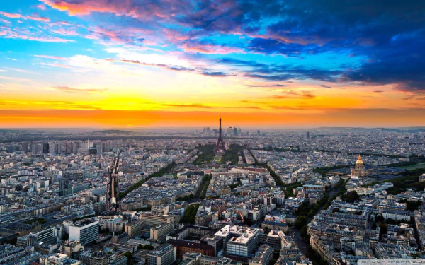 HD desktop wallpaper: Paris cityscape at sunset, Eiffel Tower centered with La Défense skyscrapers on the skyline — a dramatic man-made panorama of France