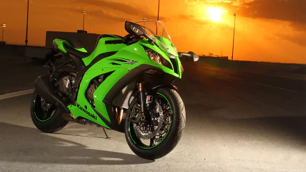 High-definition desktop wallpaper featuring a green Kawasaki Ninja motorcycle parked on a road with a dramatic sunset in the background.