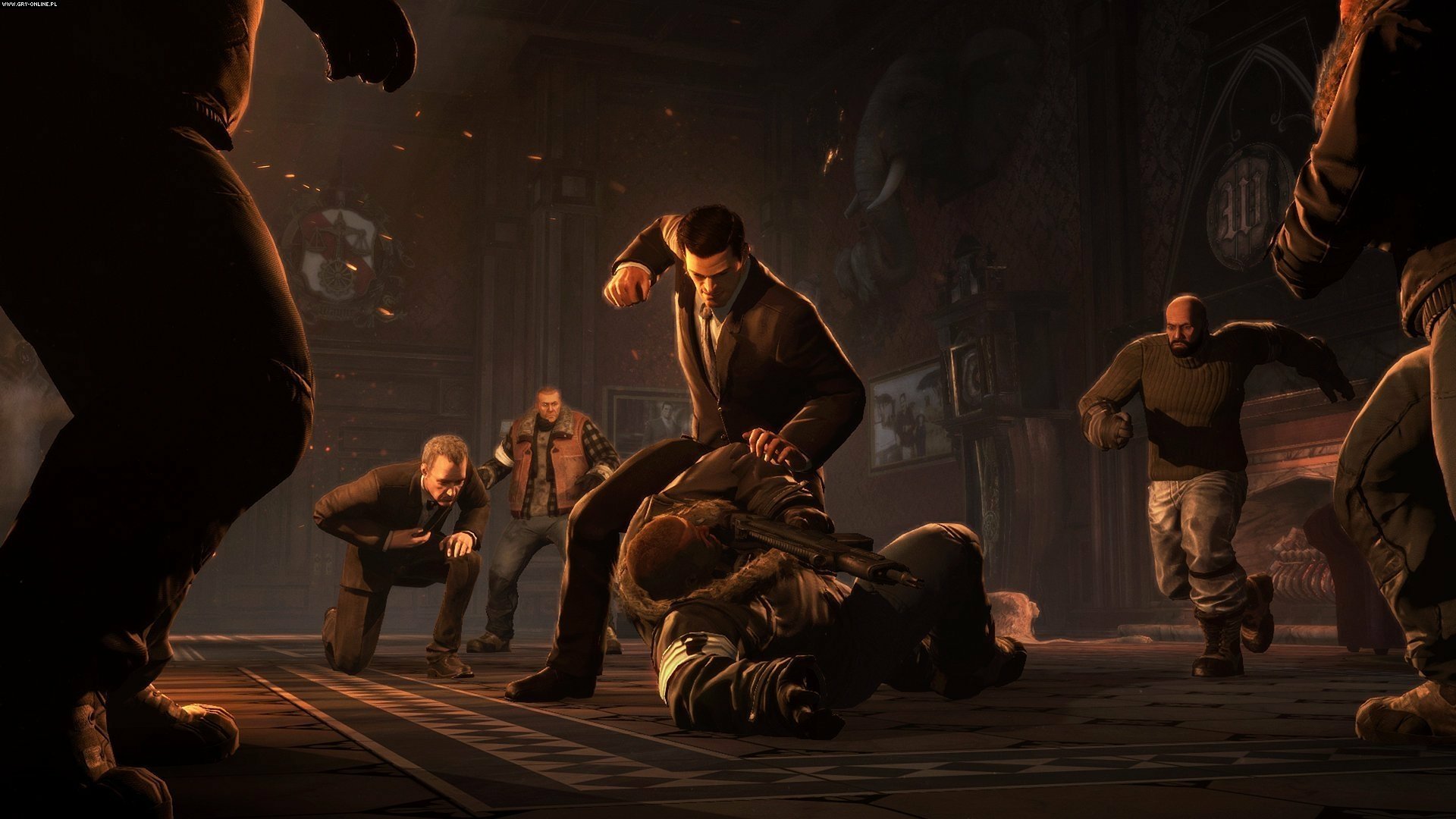 HD PC desktop wallpaper from the video game Batman: Arkham Origins: a suited man pins a fallen figure as armed thugs close in inside a dim, industrial warehouse.