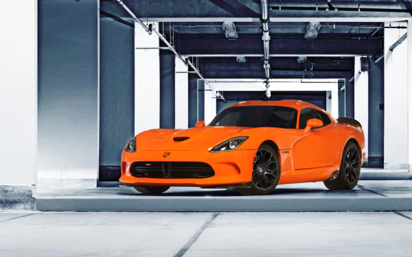 HD PC desktop wallpaper featuring a vibrant orange Dodge SRT Viper TA parked in a modern, industrial-style garage setting.