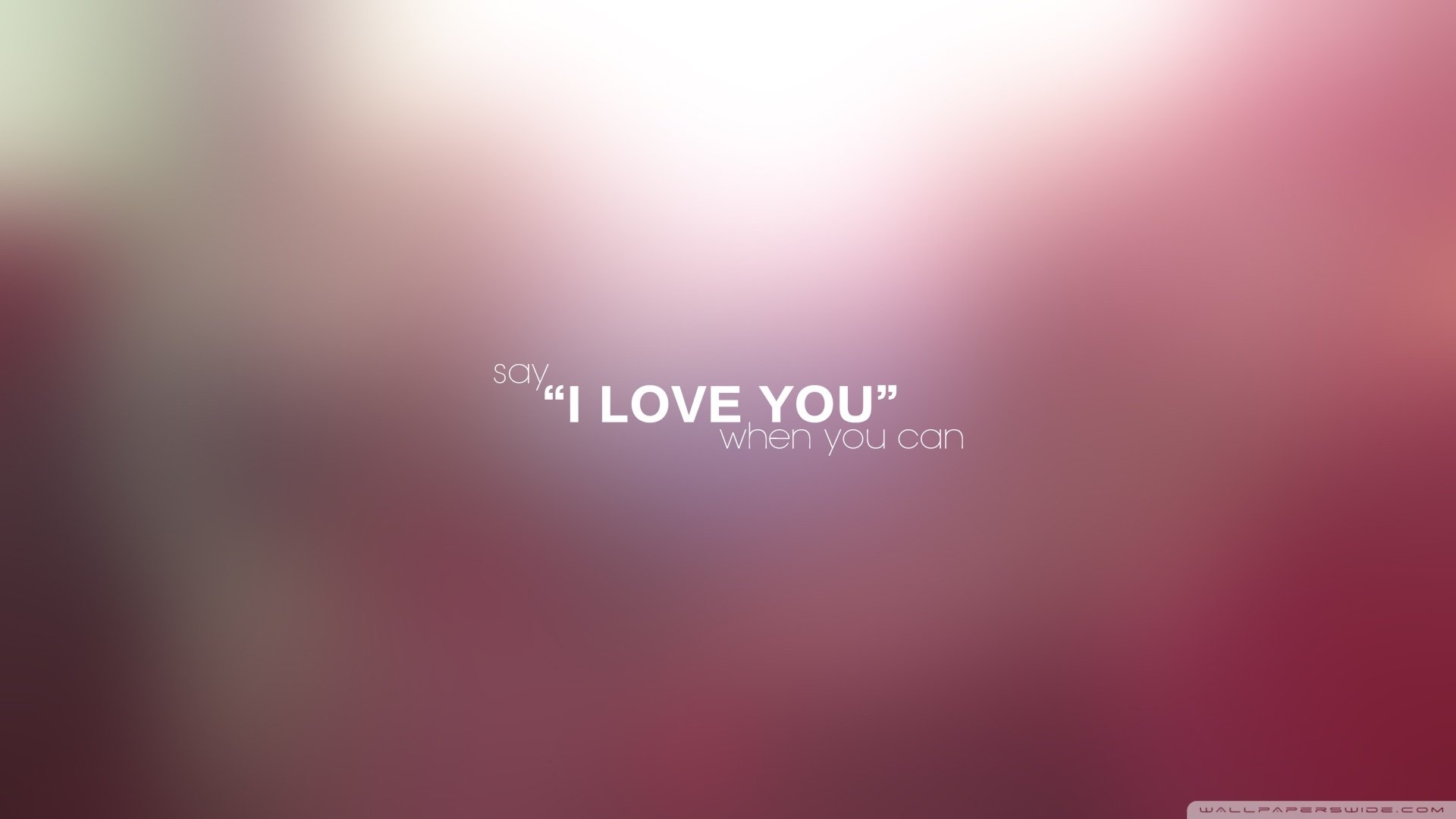 HD PC desktop wallpaper with a soft, blurred pink and purple background featuring the motivational phrase: say 'I LOVE YOU' whenever you can.