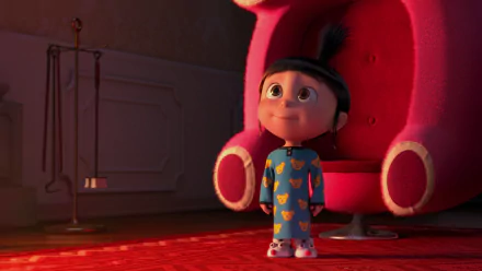Agnes from Despicable Me stands in a cozy room, gazing up with wonder. The image captures her playful spirit, showcasing a scene from Despicable Me 2 in vibrant HD quality.