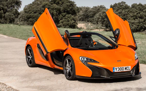 HD desktop wallpaper featuring an orange McLaren 650S Spider supercar with its butterfly doors open, parked on a sunlit driveway surrounded by greenery.