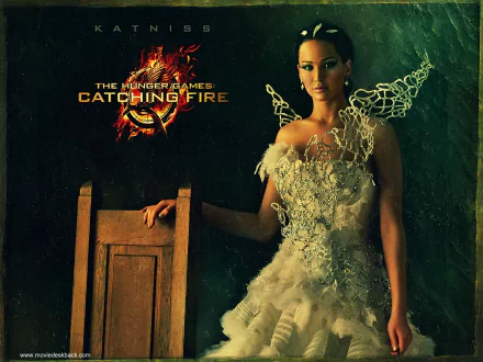 HD desktop wallpaper from The Hunger Games: Catching Fire movie featuring Jennifer Lawrence as Katniss Everdeen in an intricate dress against a dark background.