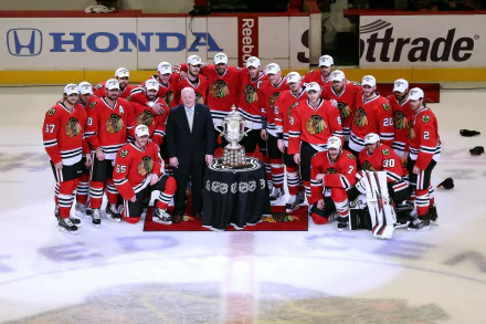 HD desktop wallpaper featuring the Chicago Blackhawks hockey team posing with a championship trophy on the ice.