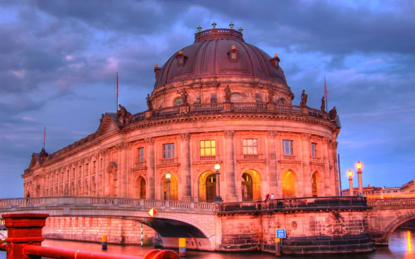 Bode Museum, Berlin: ornate historic museum building on the river Spree at dusk, warm lights against a dramatic sky — HD PC desktop wallpaper and background showcasing German architecture.
