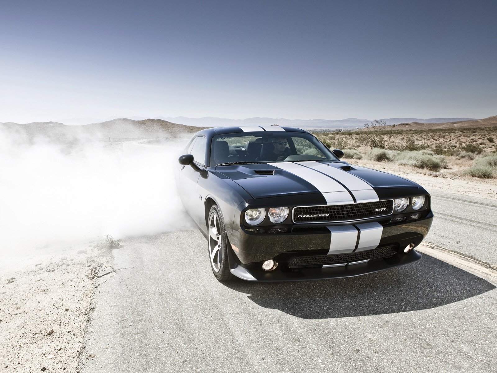 Black Dodge Challenger SRT8 392 with white racing stripes kicking up dust on a desert road — HD PC desktop wallpaper of the vehicle.